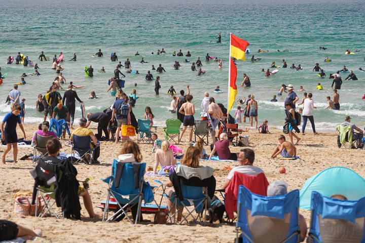 Holiday-makers on Fistral Beach on August 19, 2021 in Newquay, Cornwall, England.
