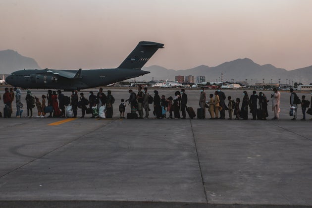 Evacuees wait to board a Boeing C-17 Globemaster III during an evacuation at Hamid Karzai International...