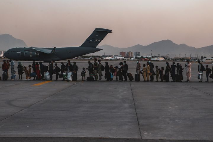 Evacuees wait to board a Boeing C-17 Globemaster III during an evacuation at Hamid Karzai International Airport in Kabul, Afghanistan.