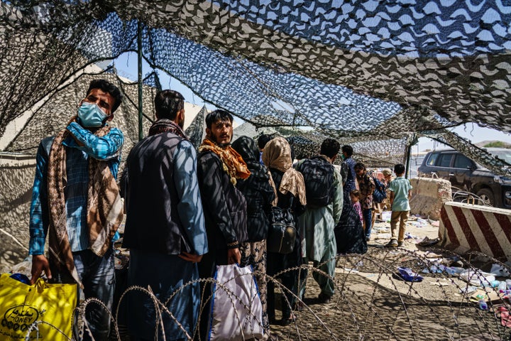 Afghan refugees leave a processing line before moving to a waiting area for a flight out of Kabul, Afghanistan, on Aug. 25.