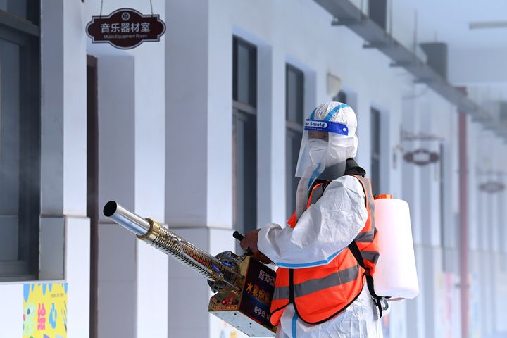 A worker disinfects the campus of a primary school in Wuhan in central China's Hubei province Wednesday, Aug. 25, 2021