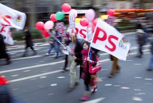 Une manifestante avec des drapeaux du parti socialiste (PS) lors d'une manifestation contre la réforme gouvernementale des retraites, le 19 octobre 2010 à Paris. (Photo JACQUES DEMARTHON/AFP via Getty Images)