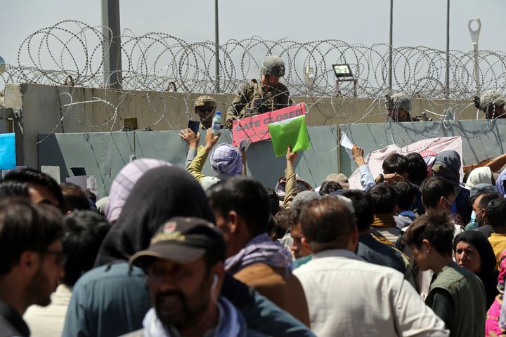 Αμερικανός στρατιώτης στο αεροδρόμιο της Καμπούλ κρατά μια πινακίδα που επισημαίνει ότι η πύλη έχει κλείσει. Εκατοντάδες Αφγανοί προσπαθούν να εγκαταλείψουν το Αφγανιστάν έπειτα από την επέλαση των Ταλιμπάν