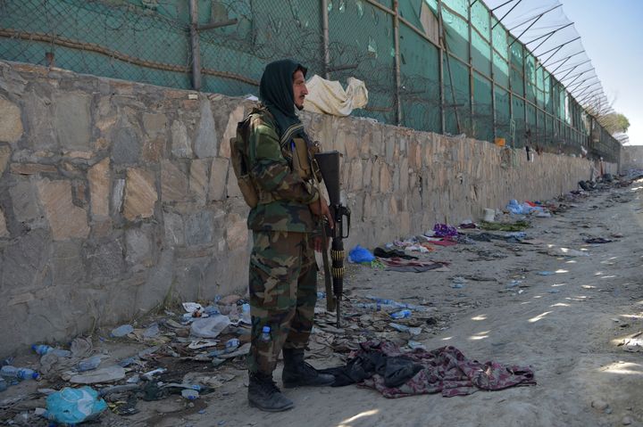 A Taliban fighter stands guard at the site of the August 26 twin suicide bombs, which killed scores of people including 13 US troops, at Kabul airport on August 27, 2021