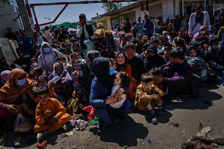 Women and children are made to crouch and wait outside the Taliban controlled check point near the airport's Abbey Gate, in Kabul, Afghanistan, Wednesday, Aug. 25, 2021