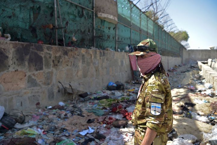 A Taliban fighter stands guard at the site of the Aug. 26 twin suicide bombs, which killed scores of people including 13 U.S.
