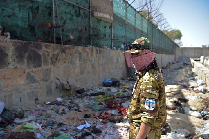 A Taliban fighter stands guard at the site of the Aug. 26 twin suicide bombs, which killed scores of people including 13 U.S. troops.