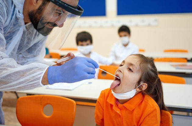 children with face mask back at school after covid-19 quarantine and lockdown, writing