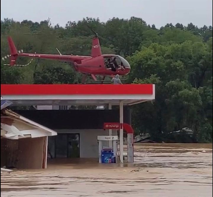 This image from video provided by Jeani Rice-Cranford shows Nashville-based helicopter pilot Joel Boyers rescuing people from a rooftop, Saturday, Aug. 21, 2021 in Waverly, Tenn. Boyers, who co-owns Helistar Aviation, said he ended up rescuing 17 people that day. He’s proud of that, but said he’s the one who should be thanking them. (Jeani Rice-Cranford via AP)