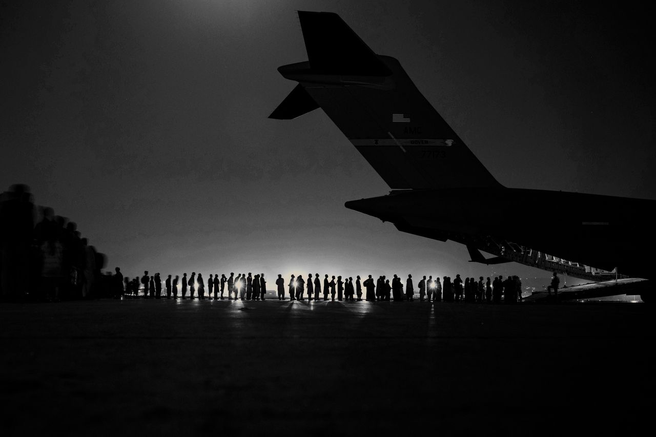 A U.S. Air Force aircrew, assigned to the 816th Expeditionary Airlift Squadron, prepare to load qualified evacuees aboard a U.S. Air Force C-17 Globemaster III aircraft in support of Afghanistan evacuation at Hamid Karzai International Airport, Afghanistan, Aug. 21.