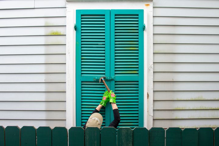 Storm shutters are hammered closed on a 100-year-old house, Friday, August 27, 2021, in New Orleans, as residents prepare for