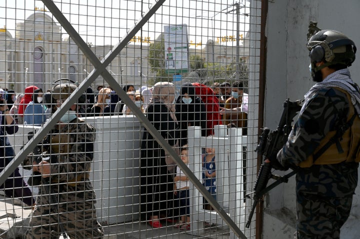 Taliban Badri fighters, a "special forces" unit, stand guard as Afghans, hoping to leave Afghanistan, wait at the main entrance gate of Kabul airport on August 28, 2021, following the Taliban stunning military takeover of Afghanistan.