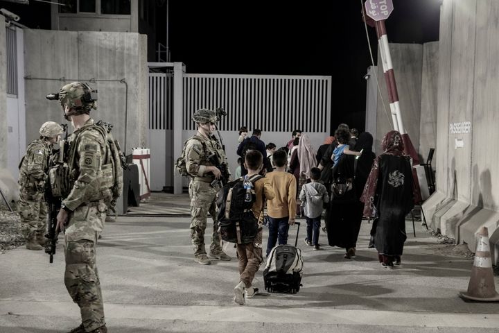 Αμερικανοί στρατιώτες συνοδεύουν Αφγανούς πολίτες στο αεροδρόμιο της Καμπούλ.