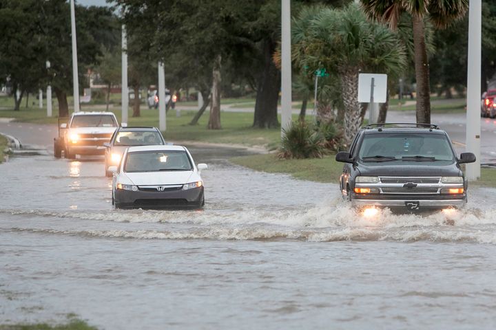 Vehicles drive through Hurricane Ida storm surge floodwater in Biloxi, Miss., on Sunday.