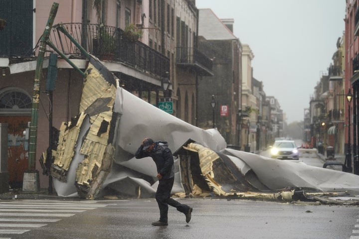 A man passes by a section of roof that was blown off of a building in the French Quarter by Hurricane Ida winds in New Orleans on Sunday.