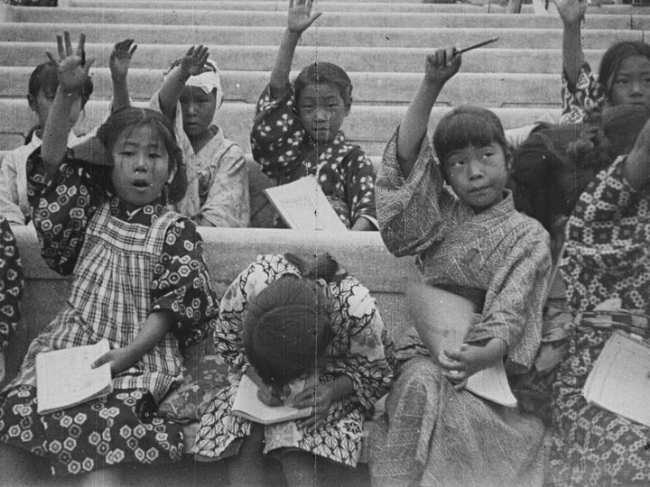 千代田区で撮影。罹災児童を対象に、文部省内の少年団日本連盟が主宰した「野外少国民学校」が開設された。本場面は、日比谷公園野外音楽堂での授業風景。
