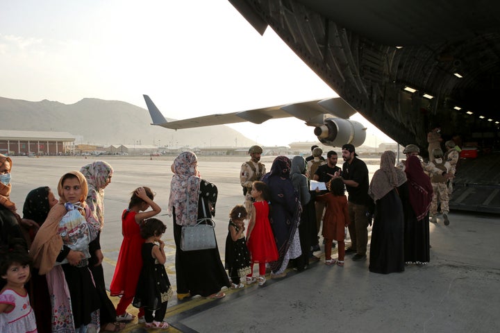 Afghans prepare to to be evacuated aboard a Qatari transport plane, at Hamid Karzai International Airport in Kabul, Afghanistan, August, 18, 2021.