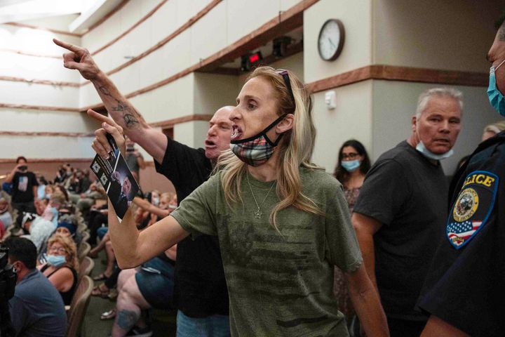 In this Aug. 12, 2021, file photo, protesters against a COVID-19 mandate gesture as they are escorted out of the Clark County School Board meeting at the Clark County Government Center, in Las Vegas. (Bizuayehu Tesfaye/Las Vegas Review-Journal via AP, File)