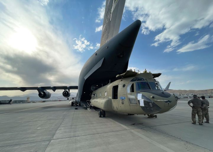 A CH-47 Chinook from the 82nd Combat Aviation Brigade, 82nd Airborne Division is loaded onto a U.S. Air Force C-17 Globemaster III on Saturday at Hamid Karzai International Airport in Kabul