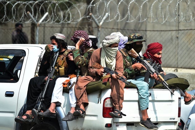 Taliban fighters guard outside the airport in Kabul on August 31,