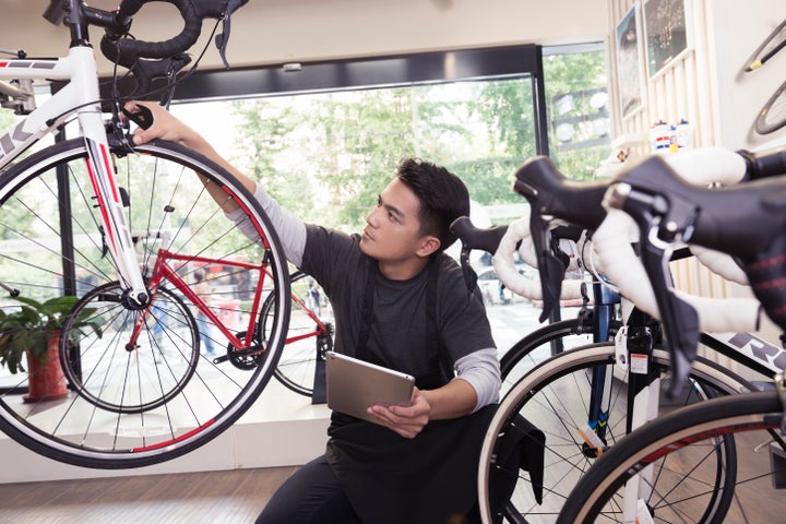 Joven comprobando una bicicleta en una tienda.