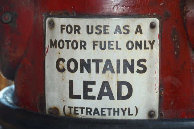 A sign on a vintage gasoline pump advises that the gas contains lead