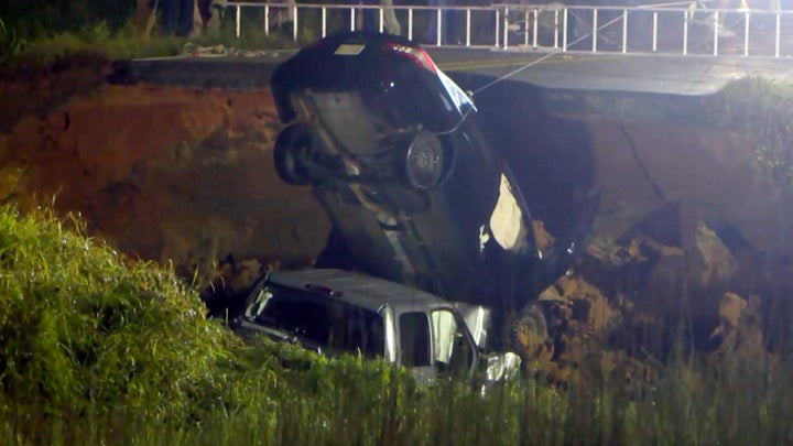 In this image made from video and provided by WLOX-TV, a vehicle is extracted from a hole on Highway 26, Tuesday, Aug. 31, 20