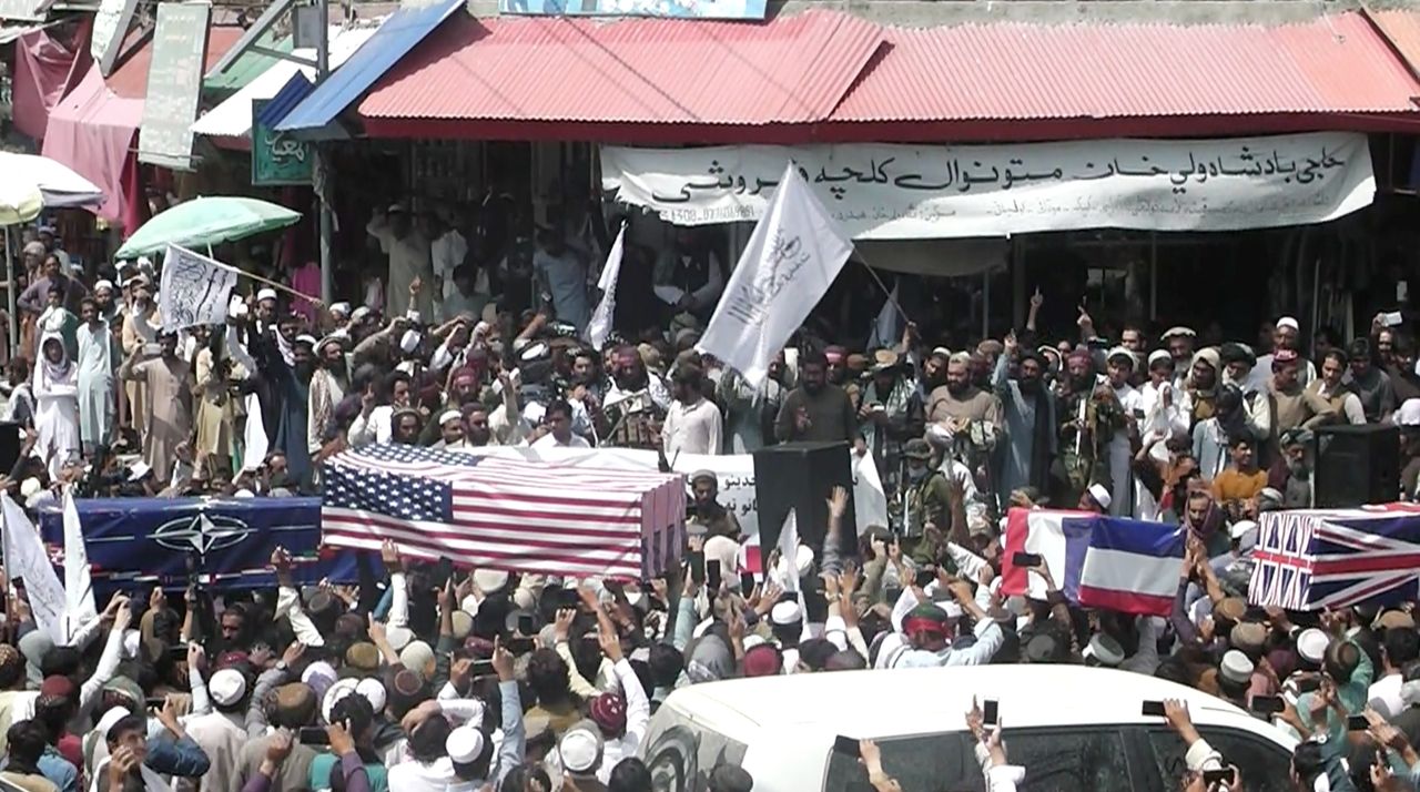 Crowd carries makeshift coffins draped in NATO's, US and a Union Jack flags during a mock funeral on a street in Khost, Afghanistan.