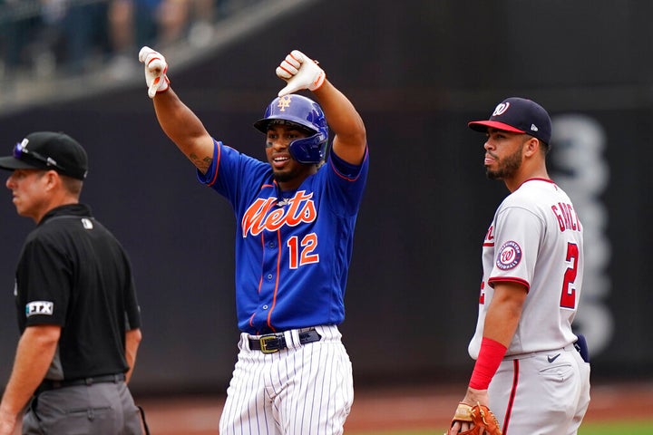 Washington Nationals shortstop Luis Garcia (2) looks on as New York Mets' Francisco Lindor (12) gestures after his double scored Patrick Mazeika and Jonathan Villa during the eighth inning of a baseball game Sunday, Aug. 29, 2021, in New York. (AP Photo/Corey Sipkin)