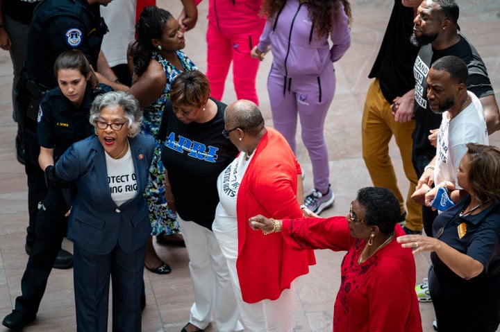 Chair of the Congressional Black Caucus Rep. Joyce Beatty (D-Ohio), left, is arrested by Capitol Police as 19 voting rights activists hold a protest in the atrium of the Hart Senate Office Building on July 15.