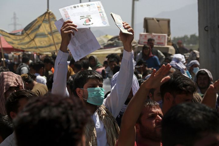 Hundreds of people gathered near an evacuation control checkpoint on the perimeter of the Hamid Karzai International Airport,