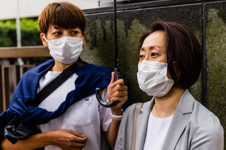 報道陣の質問に答える福田さんとパートナーの藤井美由紀さん（左）