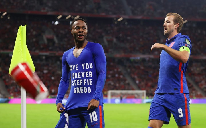 Raheem Sterling celebrates with Harry Kane after scoring their team's first goal wearing a T-shirt that reads "Love You Forever Steffie Gregg".