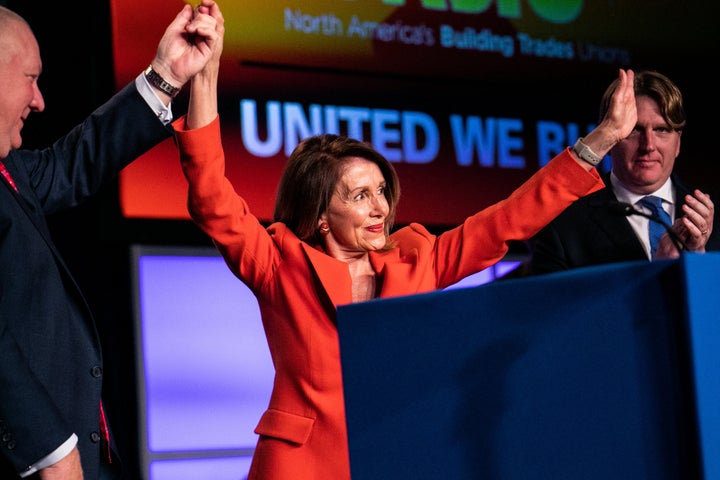 House Speaker Nancy Pelosi (D-Calif.) addresses the North America's Building Trades Unions 2019 conference. NABTU President Sean McGarvey, left, clasps her hand.