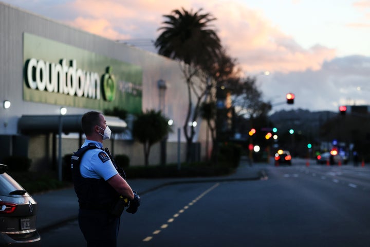 Police standing outside the supermarket where the stabbings occurred on Friday.