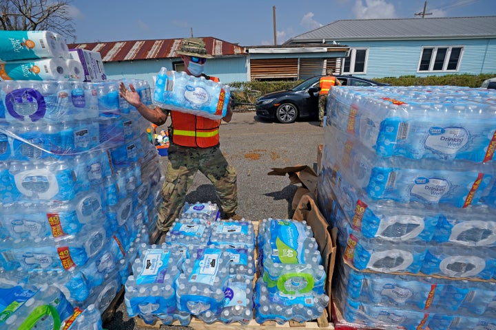 In the aftermath of Hurricane Ida, Louisiana National Guard Staff Sgt. Justin Dufreche helps load water into vehicles at a distribution site Golden Meadow, La.