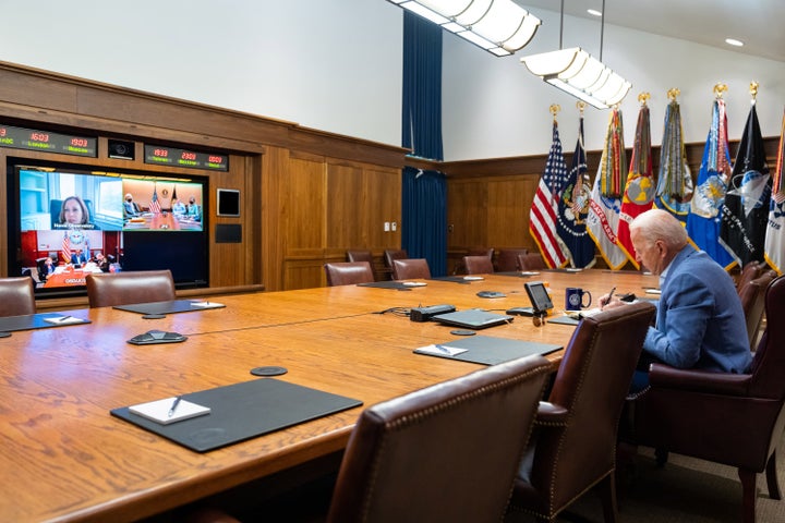 In this White House handout, President Joe Biden and Vice President Kamala Harris (on screen) speak with their national security team about efforts to draw down the civilian footprint in Afghanistan on Aug. 16, 2021.