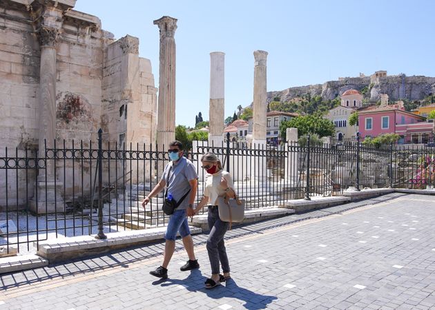 Members of the public walk through the streets of Athens, Greece on 16 June 2021. (Photo by Giannis Alexopoulos/NurPhoto via Getty Images)