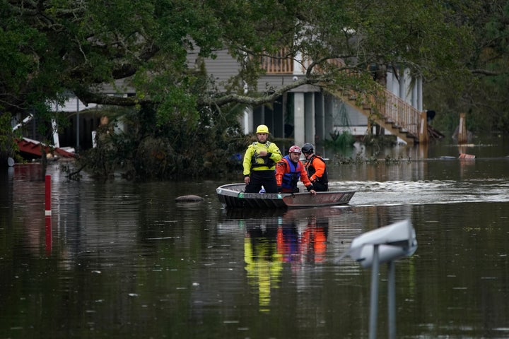 People conducting an animal rescue operation drive a boat down a flooded street in the aftermath of Hurricane Ida, Wednesday,