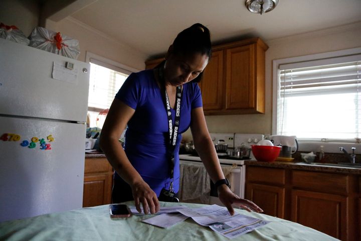 Mary Taboniar, a housekeeper at the Hilton Hawaiian Village resort in Honolulu, looks over bills at her home in Waipahu, Hawaii, Saturday, Sept. 4, 2021. Taboniar went 15 months without a paycheck, thanks to the COVID pandemic. The single mother of two saw her income completely vanish as the virus devastated the hospitality industry. Taboniar is one of millions of Americans for whom Labor Day 2021 represents a perilous crossroads. Two primary anchors of the government's COVID protection package are ending or have recently ended. (AP Photo/Caleb Jones)
