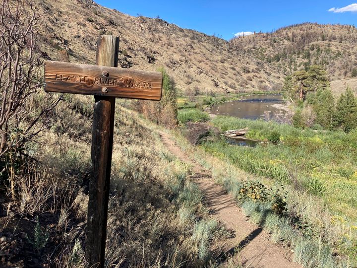 A trail sign burned by a recent wildfire stands near the North Platte River in southern Wyoming, on Tuesday,Aug. 24, 2021. (AP Photo/Mead Gruver)