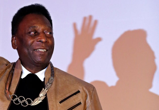 Brazilian soccer legend Pele poses for picture after receiving an Olympic necklace from President of...
