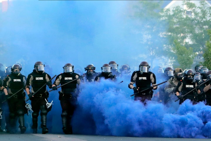 FILE - In this May 30, 2020, file photo, Minnesota State Police officers approach a crowd of protesters in Minneapolis. The Minnesota State Patrol purged e-mails and texts messages immediately after their response to protests in the wake of George Floyd’s death last summer, according to court testimony in a lawsuit that alleges the State Patrol targeted journalists during the unrest. (AP Photo/Julio Cortez, File)