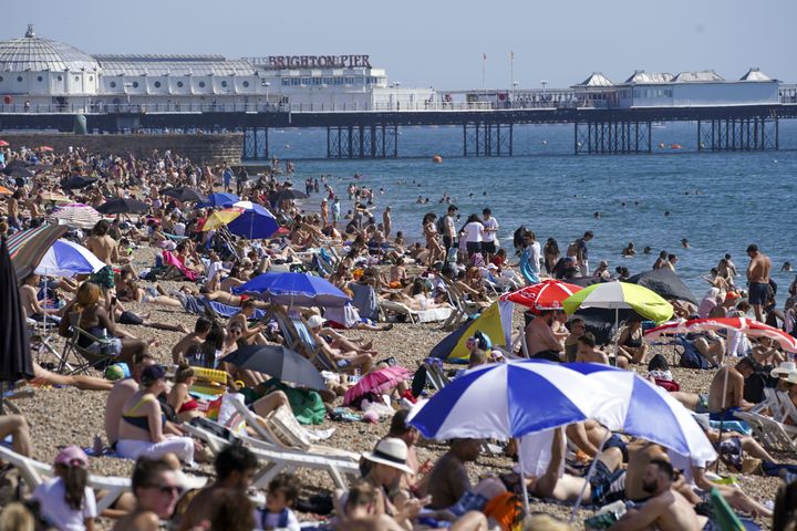 People enjoy the warm weather at Brighton beach in West Sussex.