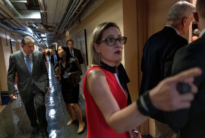 Conservative Democratic lawmakers including Sens. Kirsten Sinema of Arizona (foreground) and Joe Manchin of West Virginia (far left) have tried to scale back the big spending bill Democrats want to pass this fall. That has made it harder to find enough money to fund the bill's components, including the proposal to bolster home- and community-based services for elderly and disabled Americans.