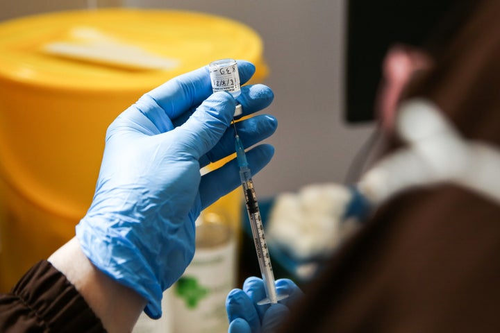 LONDON, UNITED KINGDOM - 2021/08/18: A vaccinator prepares to administer the Pfizer Covid-19 vaccine to a woman at a vaccination center in London. (Photo by Dinendra Haria/SOPA Images/LightRocket via Getty Images)