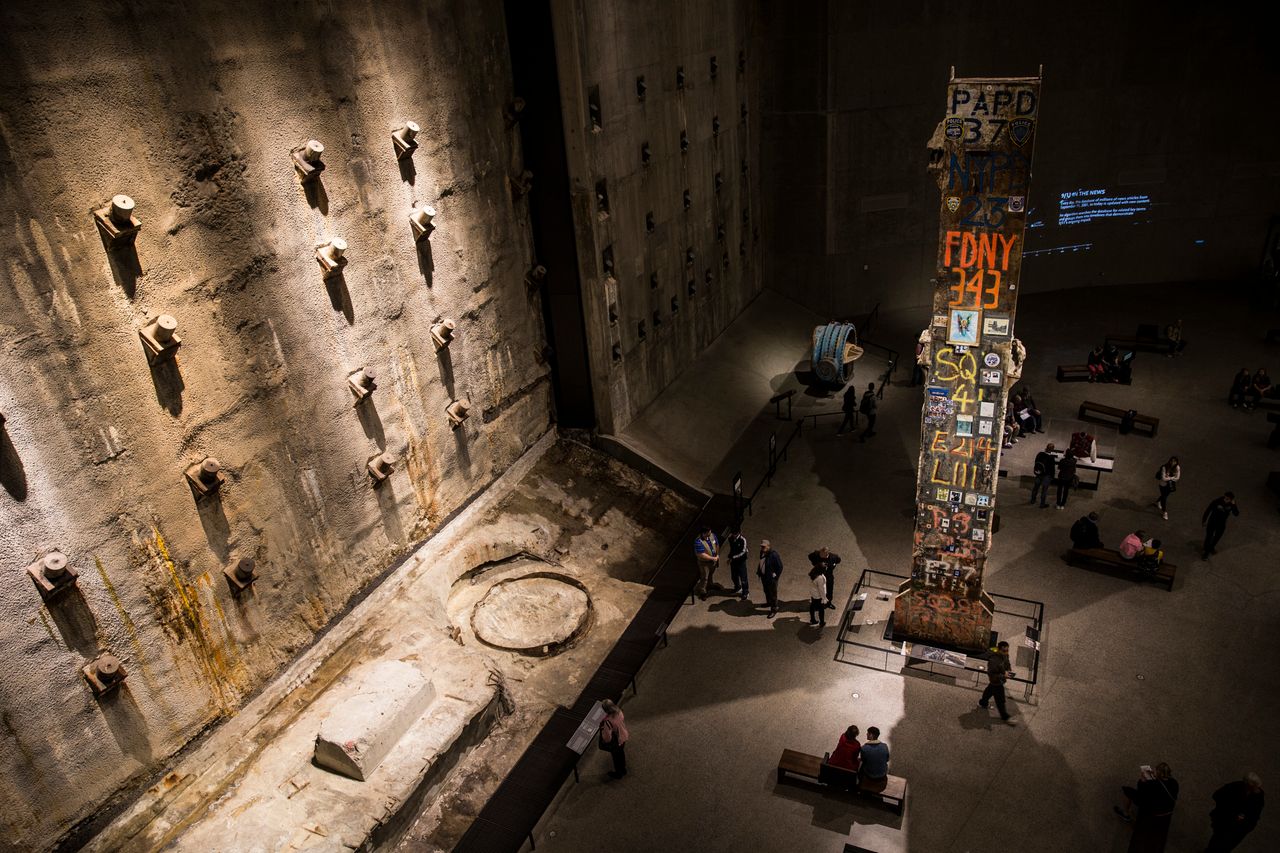 The inside of the National 9/11 Memorial Museum in New York, United States, on Oct. 12, 2017. On the left is the "slurry wall," which protected the original World Trade Center towers from the Hudson River. On the right is the Last Column, the final remaining piece of the towers, which first responders kept intact during the recovery and excavation efforts and decorated. (Photo by Manuel Romano/NurPhoto via Getty Images)