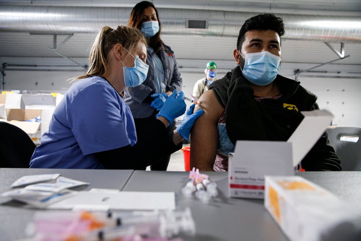 Tyson Foods workers receive COVID-19 vaccines from health officials at the facility in Joslin, Illinois. 