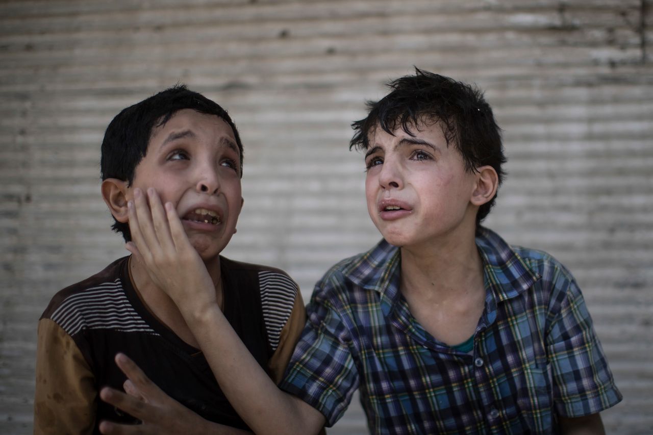 Ο Ζαΐντ και ο Χοντάφγια Αλι, 12 και 11 χρονών, κλαίνε μετά την κατάρρευση του σπιτιού τους από βόμβα, κατά τις συγκρούσεις του Ιρακινού στρατού με το Ισλαμικό Κράτος, στη Μοσούλη του Ιράκ, στις 24 Ιουνίου 2017. 