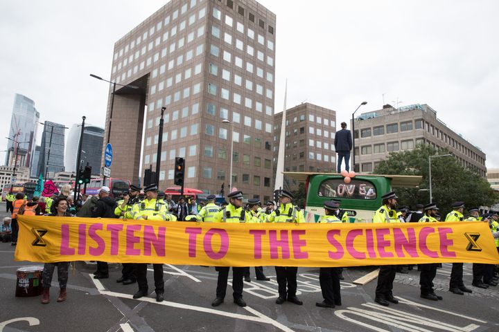 Environmental activists from Extinction Rebellion hold a banner calling on the government to cease all new fossil fuel investment